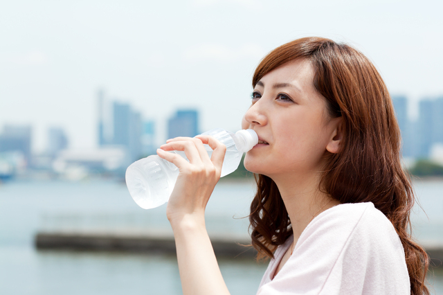 Beautiful young woman drinking water. Portrait of asian woman.